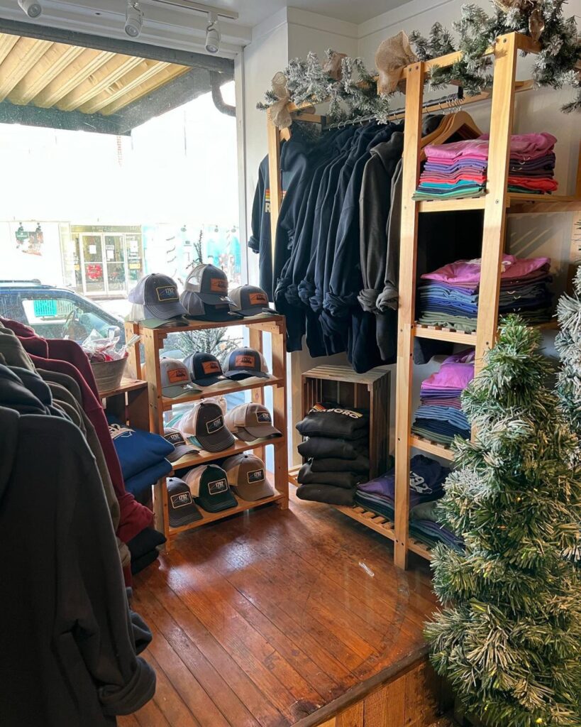 Clothing hung on hangers and folded on wooden shelves in a clothing store