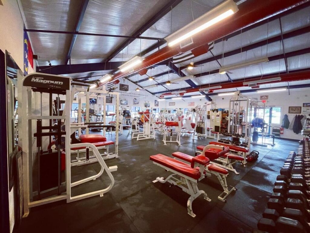 The interior of a gym full of exercise machines and free weights