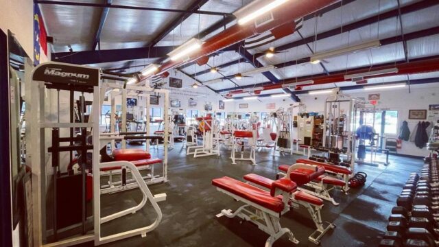 The interior of a gym full of exercise machines and free weights