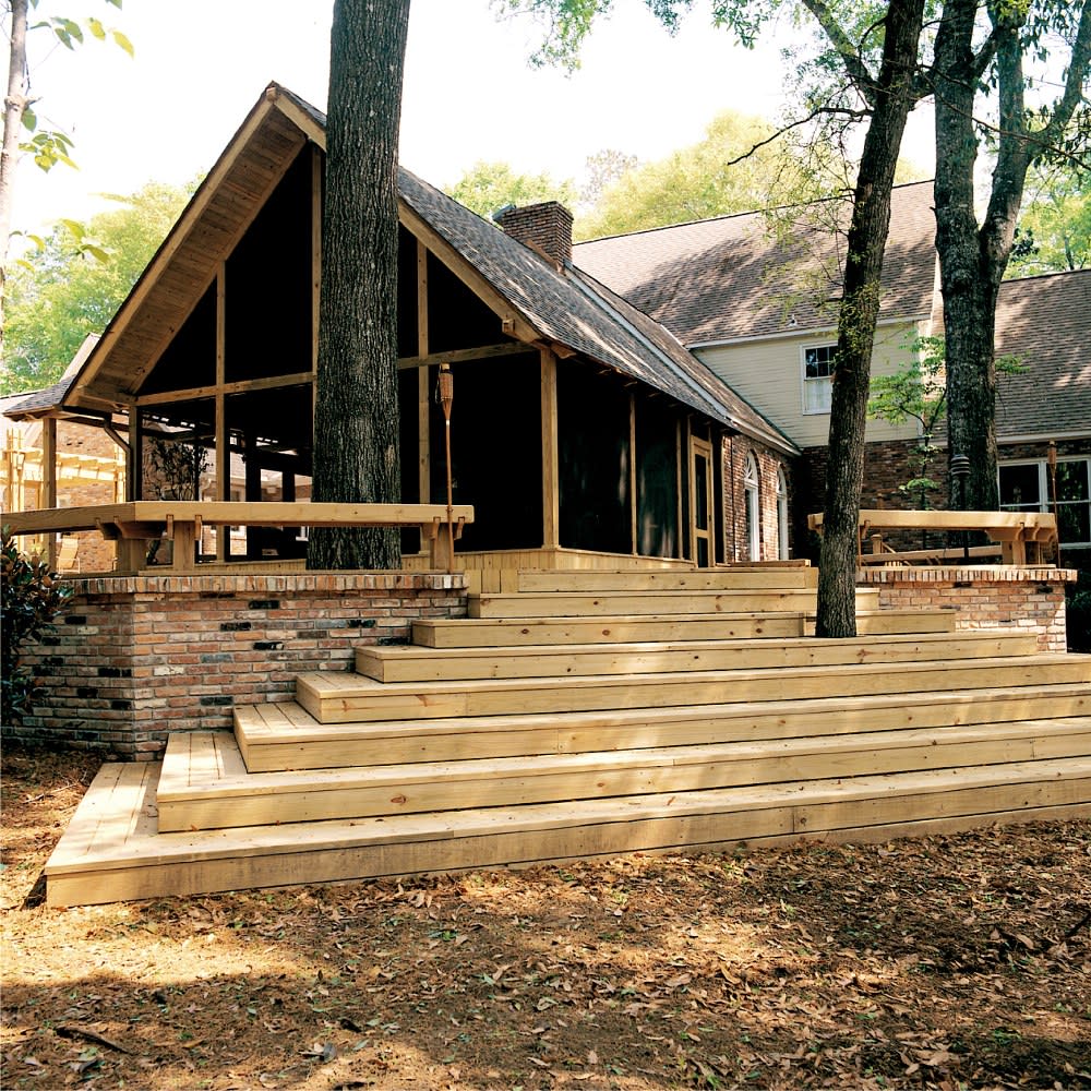 Wooden steps leading up to a porch on a red brick building