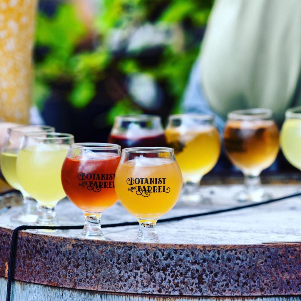 Glasses of different beer arranged on top of a barrel