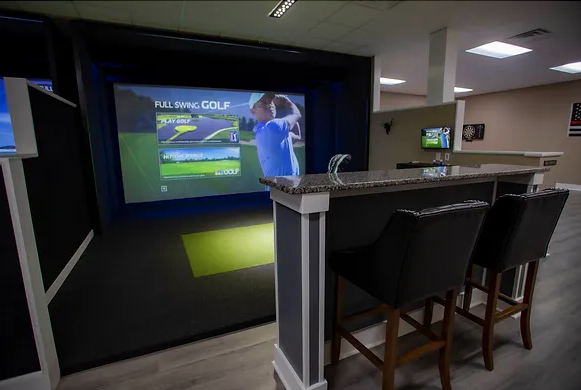 A bar counter with two black chairs facing a TV screen