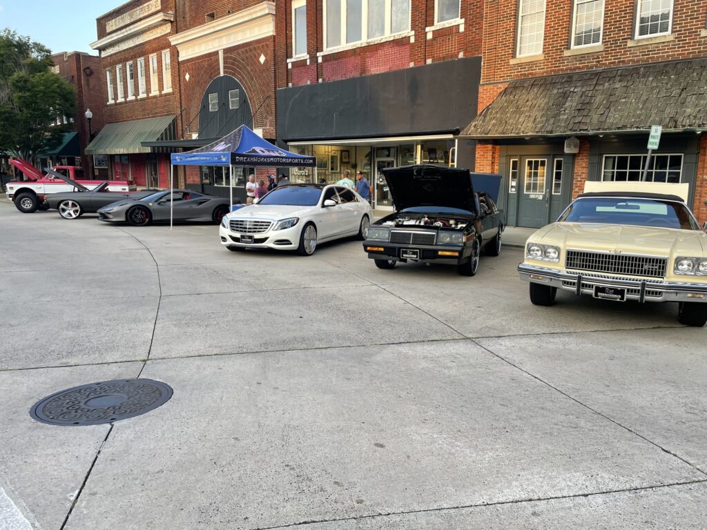Cars parked on a street for a car show.