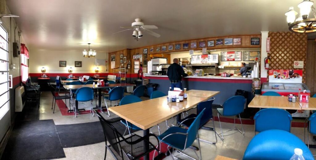 A diner with laminate tables and blue plastic chairs