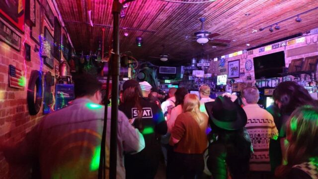 People stand in a sports bar