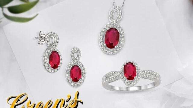 A matching set of earrings, necklace and ring with red center stones and halos of white stones