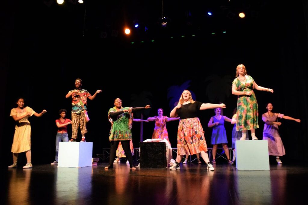 Performers sing and dance on stage