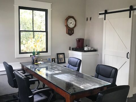 Five black office chairs around a wooden table