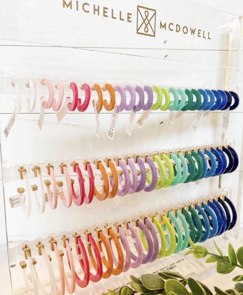 A colorful display of acrylic hoop earrings arranged in rainbow order