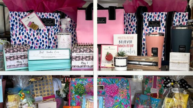 A display of teacher appreciation gifts including water bottles and jewelry