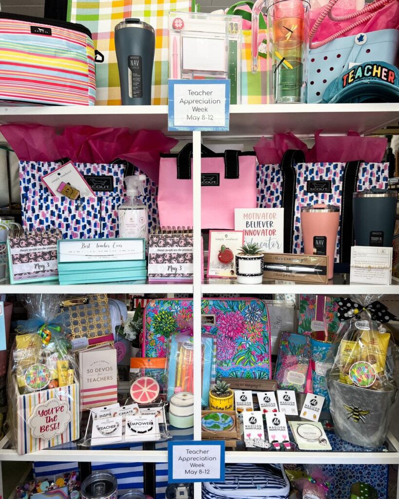 A display of teacher appreciation gifts including water bottles and jewelry