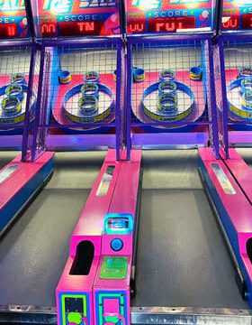 A pink and purple skee ball machine