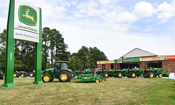 John Deere tractors parked in front of a store