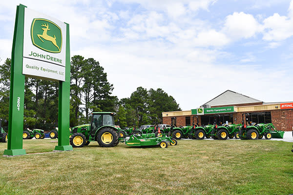 John Deere tractors parked in front of a store