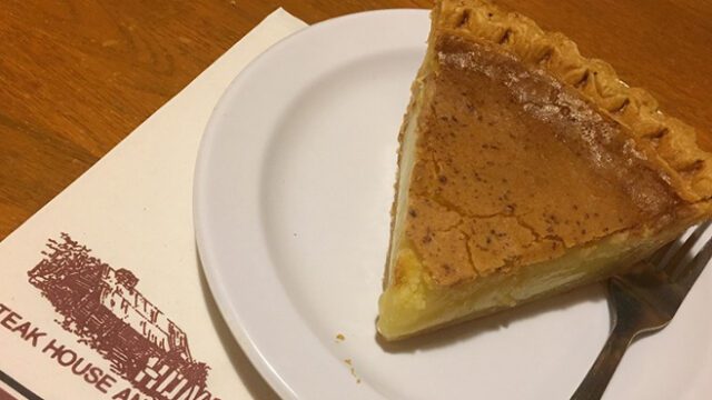 A slice of buttermilk pie and a fork on a white plate