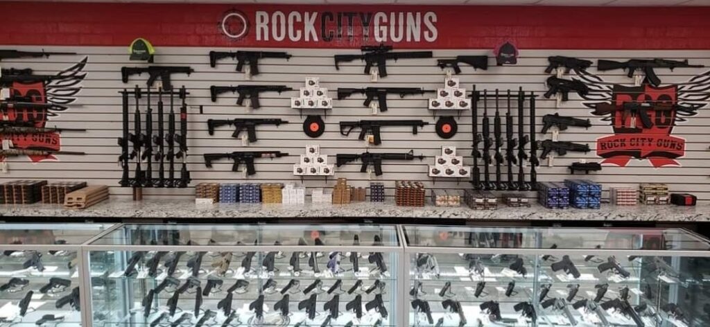 A display of guns in glass cases and on the back wall behind the counter