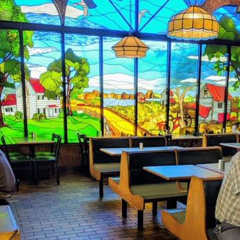 A colorful mural of country homes on a wall inside a restaurant