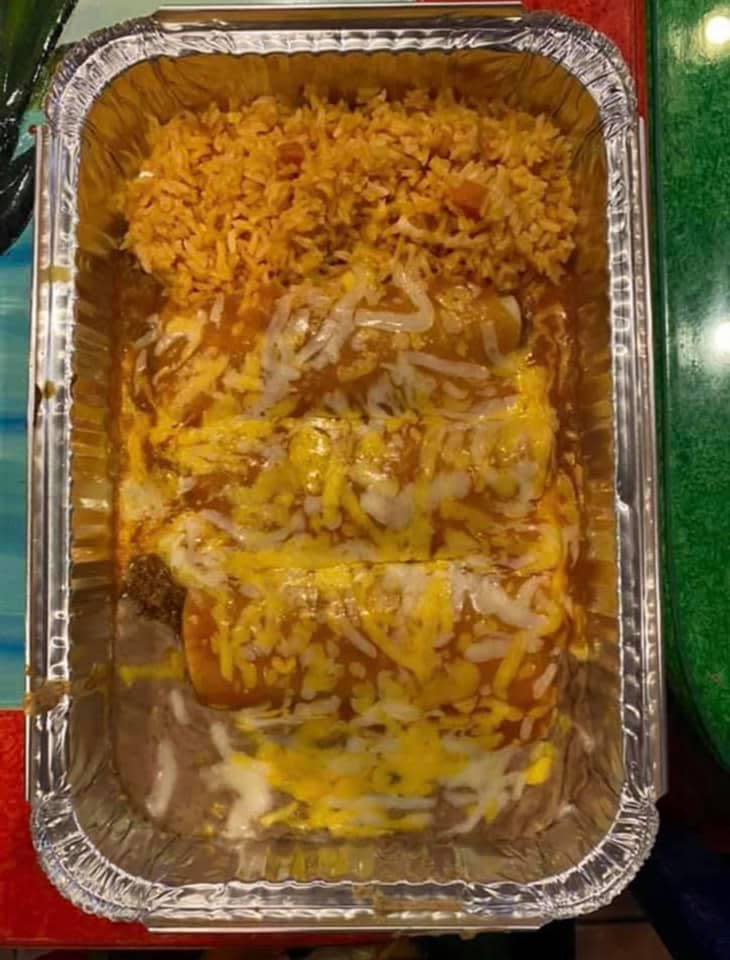 Three enchiladas topped with cheese plus a side of rice in a rectangular foil container