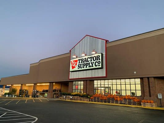 Front of Tractor Supply Co. with orange pumpkins and yellow flowers on display
