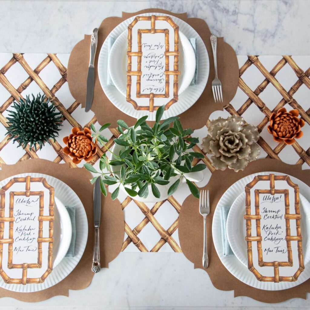 Table settings with white plates, brown placements and flower centerpieces