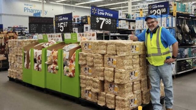 A Wal-Mart employee standing by bales of hay inside the store