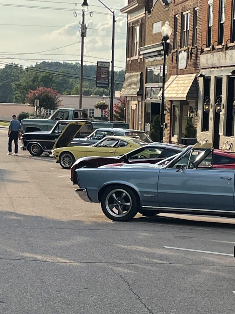 Classic cars parked on a street for a car show.
