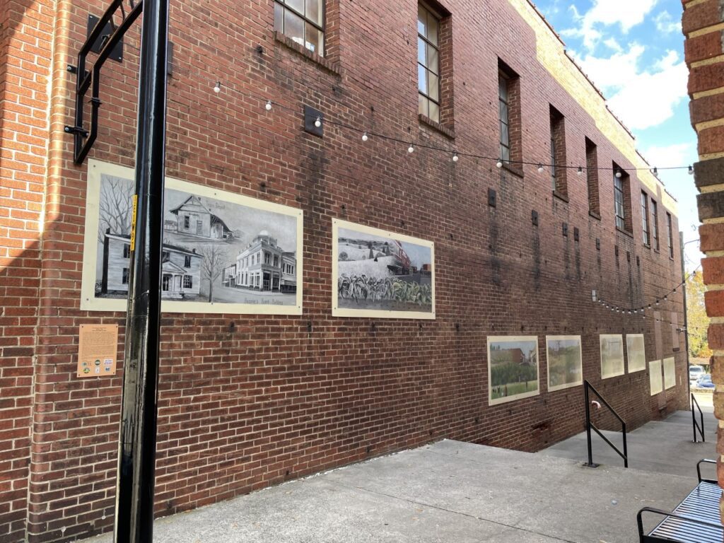 Wall art displayed outside on a red brick building